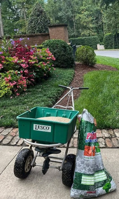 Spreading lawn seed in Monroe, GA to thicken the grass.